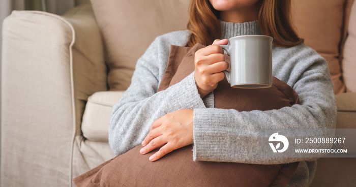 Closeup image of a young woman drinking hot coffee and relaxing at home