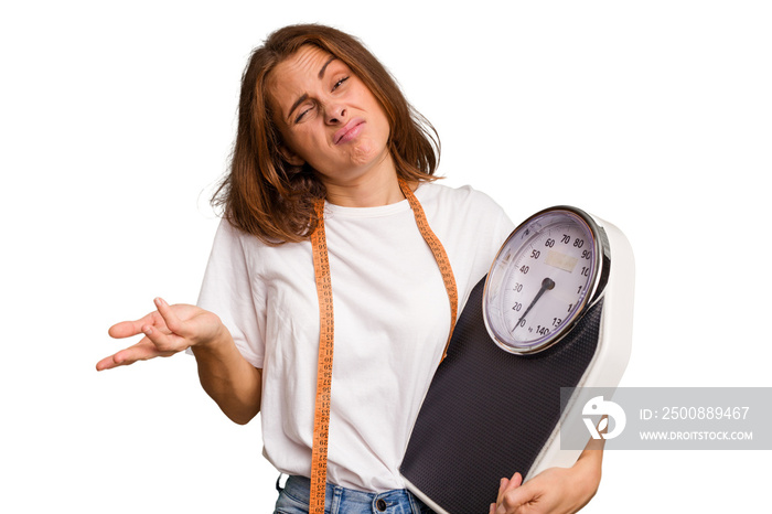 Young nutritionist caucasian woman holding scale and mesure tape isolated