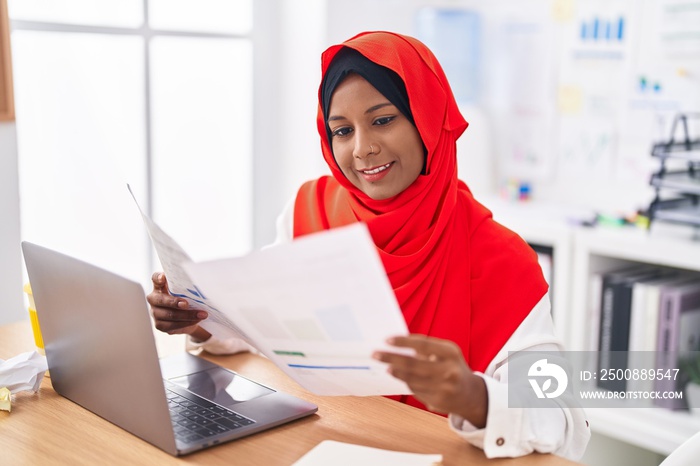 Young beautiful woman business worker using laptop reading document at office