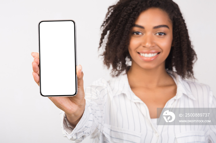 Black millennial woman showing blank phone screen