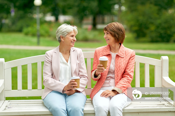 old age, retirement and people concept - two senior women or friends drinking coffee and talking at park