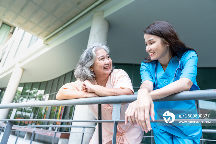 Elderly Asian woman patient Standing and talking to female doctor, smiling and happy that the treatment of sickness improved, to elderly health care concept.