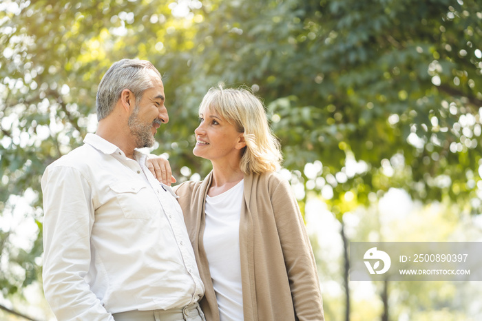 Elderly couple lifestyle concept. Husband and wife looking at each other face nature background