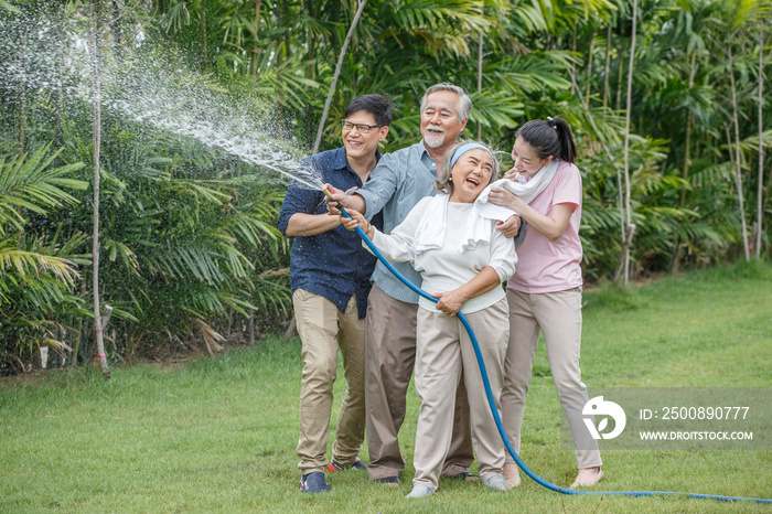 happy asian family watering the plants  in the front lawn at home  Spend time together lifestyle in garden