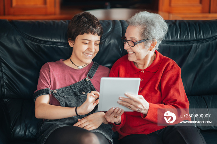 Granddaughter teaches her grandmother how to use a tablet