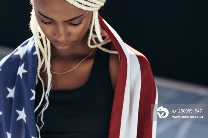 Female athlete with american flag on her back