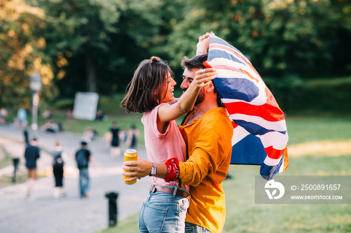Young couple dancing at a festival in the park with a United Kingdom flag