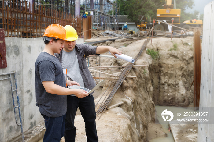 Team of construction workers discussing project details with blueprint in construction site.