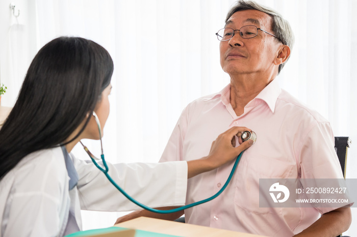 Doctor listening to patient’s heart rate with stethoscope in medical office