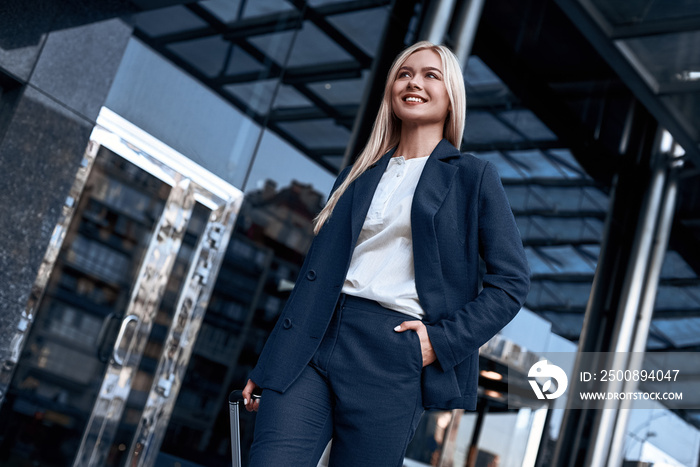 Travel, business trip. People and technology concept - happy young woman with travel bag on city street