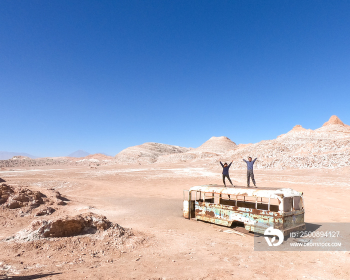 homem e mulher em cima de ônibus abandonado no Deserto do atacama