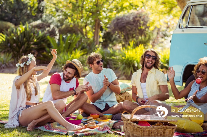 Group of friends having fun together near campervan