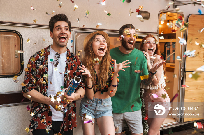 Group of cheerful smiling friends standing at the trailer outdoors