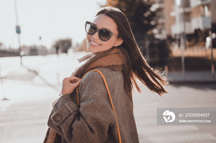 Photo of pretty dreamy woman wear grey coat dark glasses wind air blowing enjoying morning sunshine outside urban city street