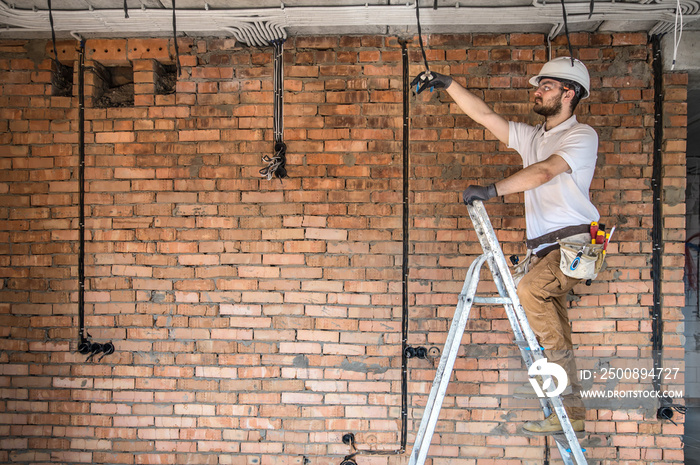 Electrician with tools, working on a construction site. Repair and handyman concept.