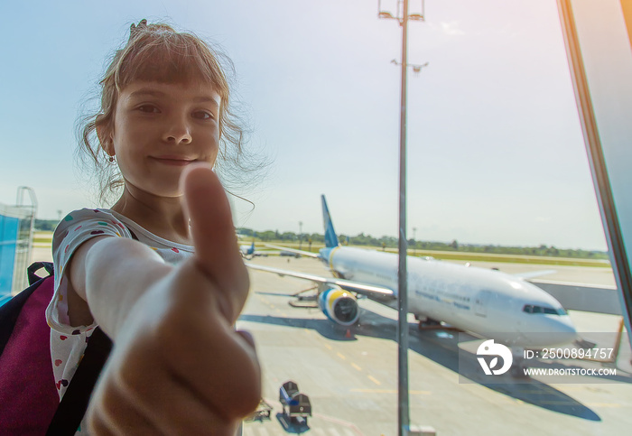 A child at the airport on the background of the aircraft. Selective focus.