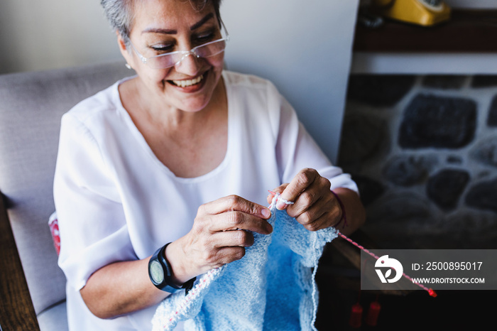 hispanic senior woman retired knitting at home in Mexico Latin America