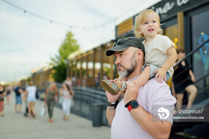 Father and his toddler son explore beautiful streets of Warsaw’s Old Town. Dad holding his infant son.