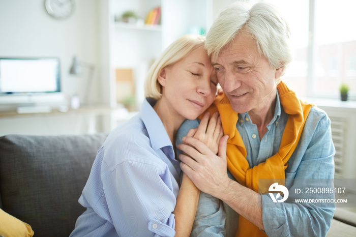 Portrait of mature couple in love embracing tenderly at home , copy space