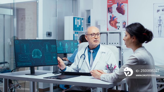 Old experienced practitioner presenting modern X Ray on computer display to young patient. Practitioner explayning medicine computer diagnosis image X Ray. Radiology health care scan analyzing in