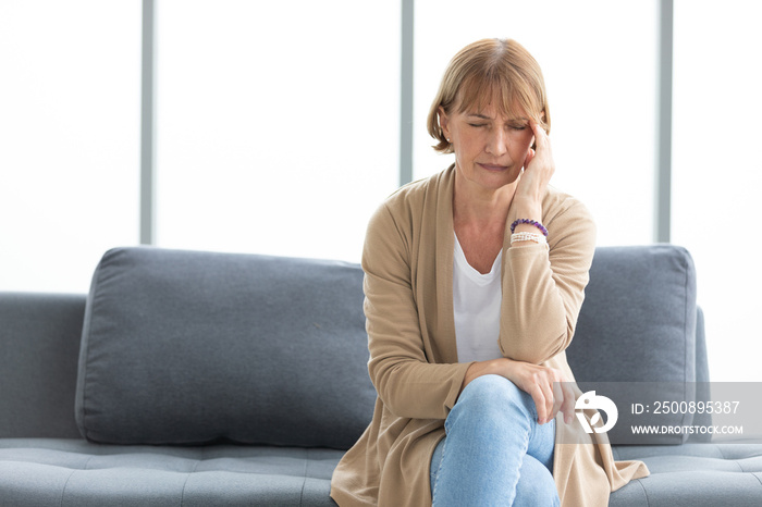 senior woman have a headache on a sofa