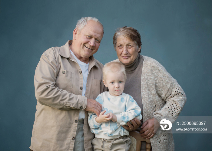 great grandmother and great grandfather with great grandson on blue background