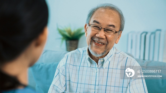 A young female doctor inquires about personal information of a contented senior at home. Medical care for the elderly, elderly illness, and nursing homes, home care.