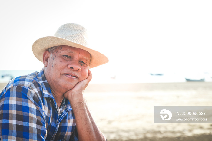 The elderly man wears a hat smiling happily. Come to the sea.