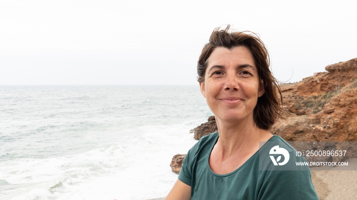 smile middle aged woman walking along sea coast beach