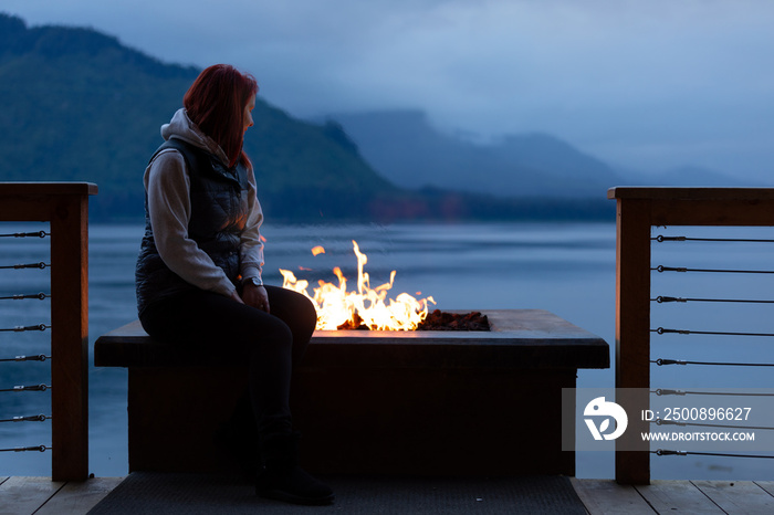 Photo of a woman by the fire in Icy Strait Point, Alaska