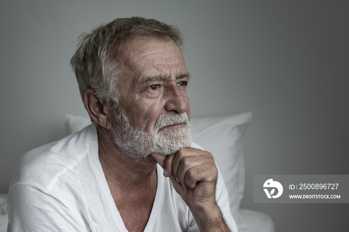 senior man thinking or try to remember alone on bed in white room