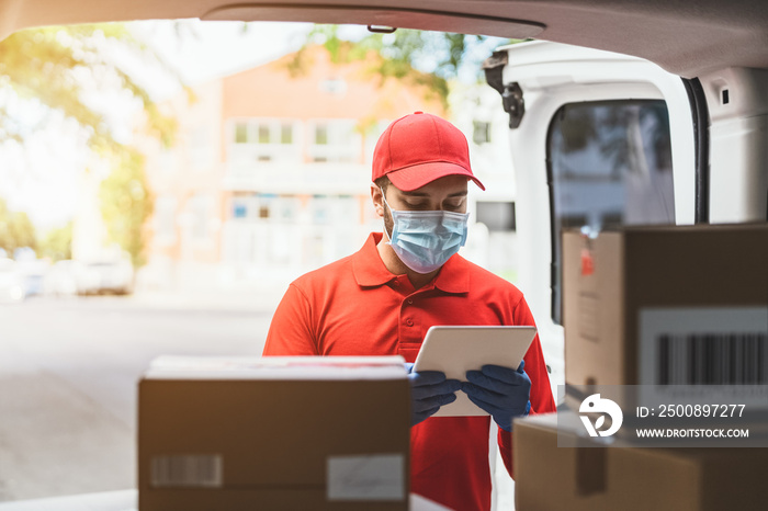 Delivery man wearing face protective mask to avoid corona virus spread - Young express courier working during coronavirus outbreak - Deliver and online buying concept