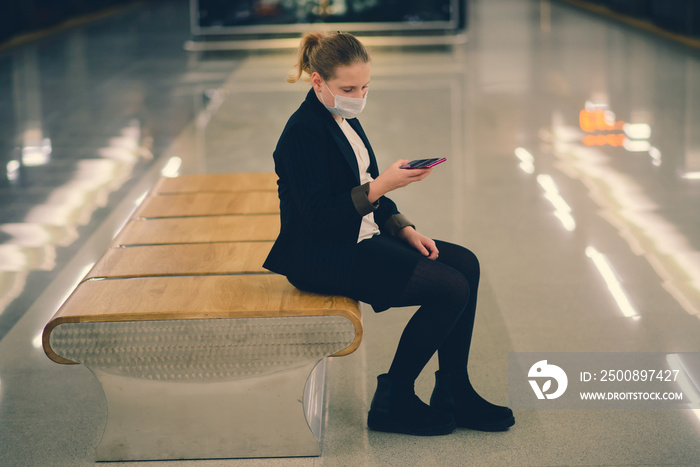 Nice pretty worried young girl wearing mask and headphones in a bus, train or metro going to school