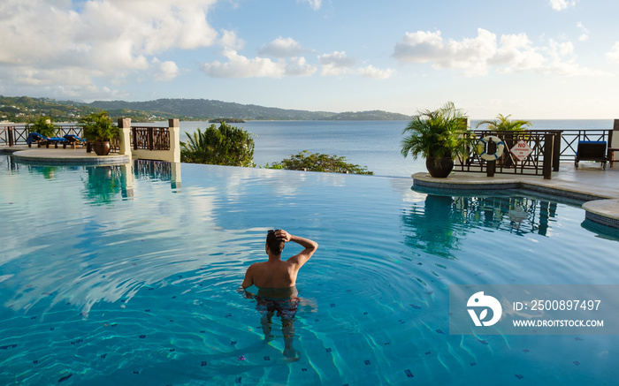 Young men in a swim shorts at Saint Lucia Caribbean, men at infinity pool during sunset. man in a swim short at the pool