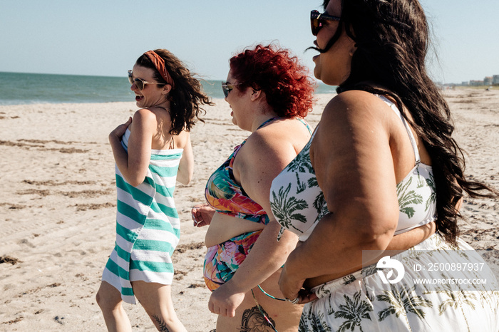 3 women run towards the beach