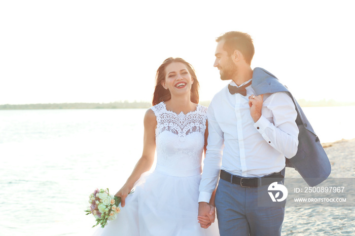 Happy wedding couple on sea beach