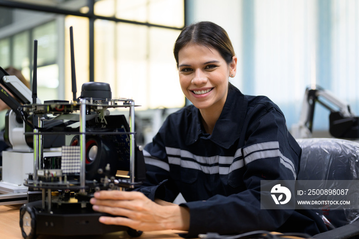 Female maintenance engineer checking and repairing automatic robotic machine at industrial factory, Technician worker working with robotic system in factory