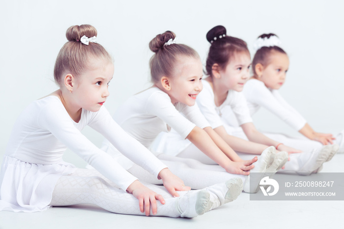 Group of graceful pretty little ballerinas practicing during class at a classical ballet school their first choreographed dance