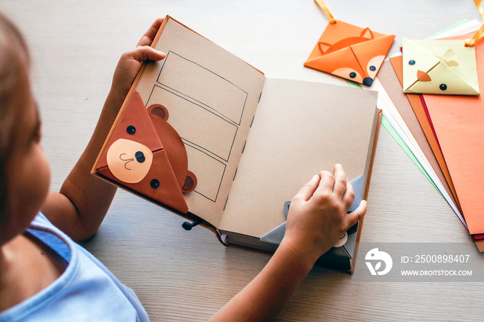 Girl holding a book with crafted paper bookmarks