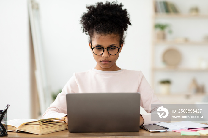 Black Teen Girl At Laptop Doing Homework Online At Home