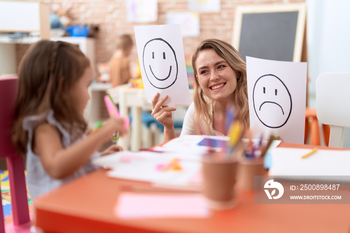 Teacher and toddler sitting on table having emotion therapy at kindergarten