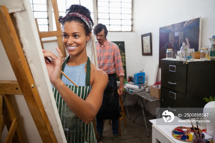 Man and woman painting on canvas