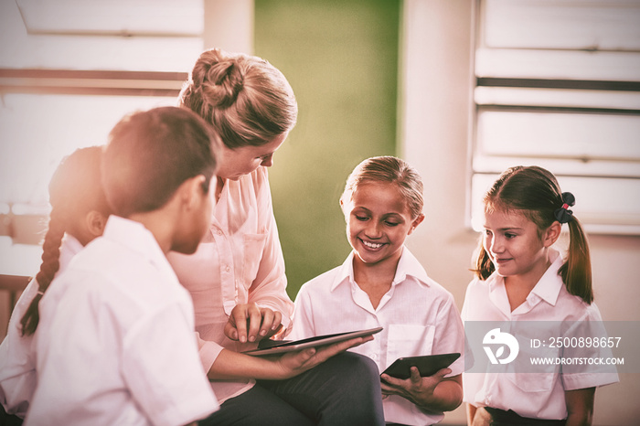 Teacher teaching kids on digital tablet