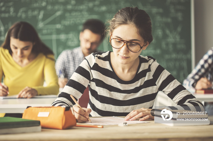 Students in examination solving questions wrting