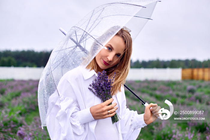 pretty woman holding umbrella on stormy weather, standing in open field, checking rain. shallow depth of field photo