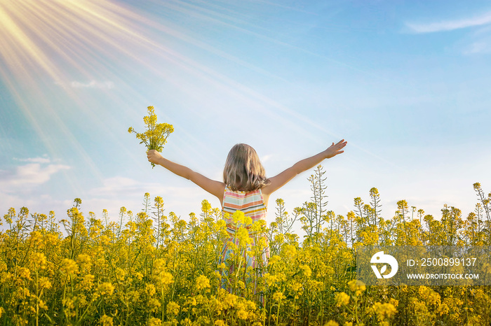 A child in a yellow field, mustard blooms. Selective focus.