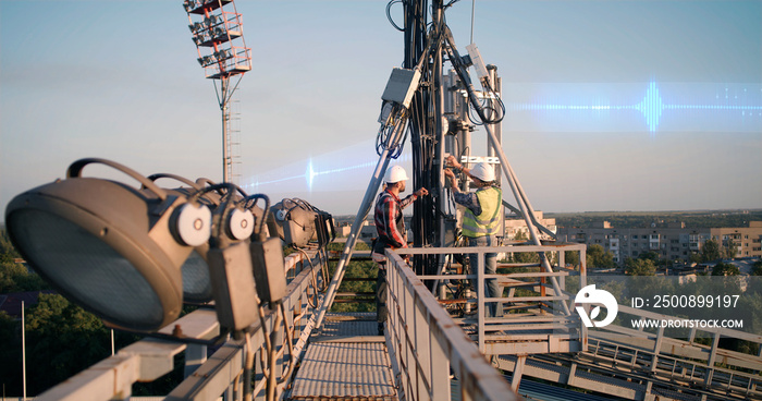 Male technicians fixing transmitting antenna