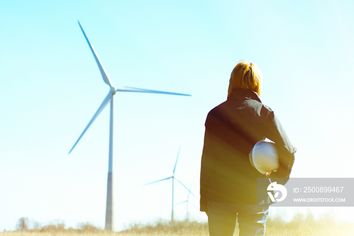 Woman engineer or architect with white safety hat and wind turbi