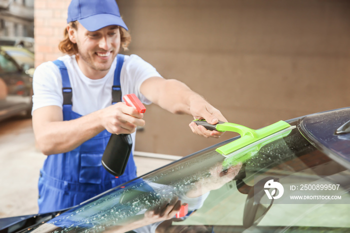 Male worker tinting car window outdoors