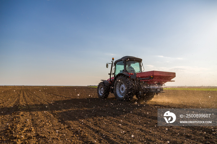 Farmer fertilizing arable land with nitrogen, phosphorus, potassium fertilizer